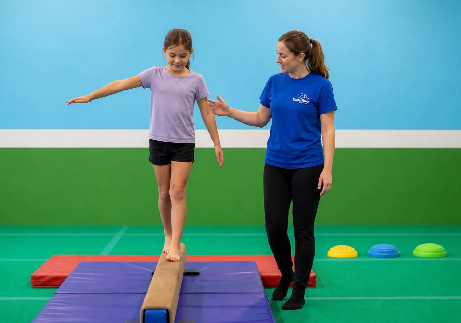 TumbleTown coach supporting a child crossing a low balance beam