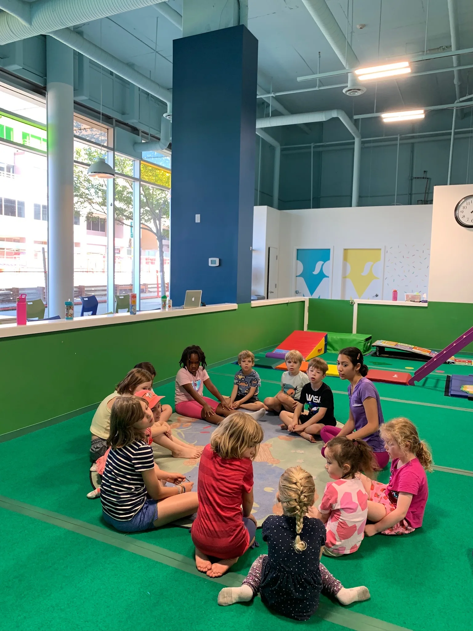 A real TumbleTown class gathered for circle time inside the gym