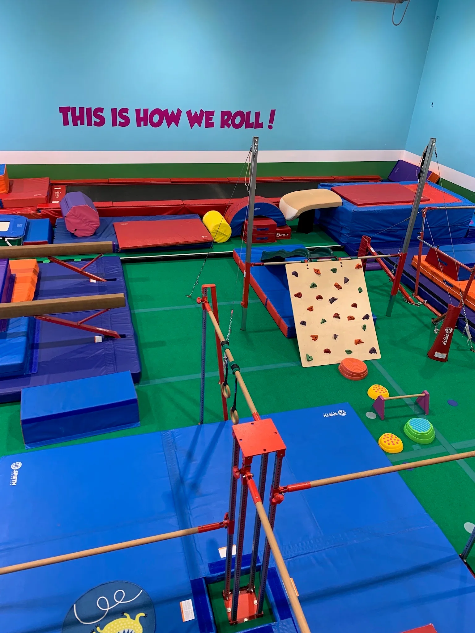 "THIS IS HOW WE ROLL!" painted above the equipment floor at TumbleTown