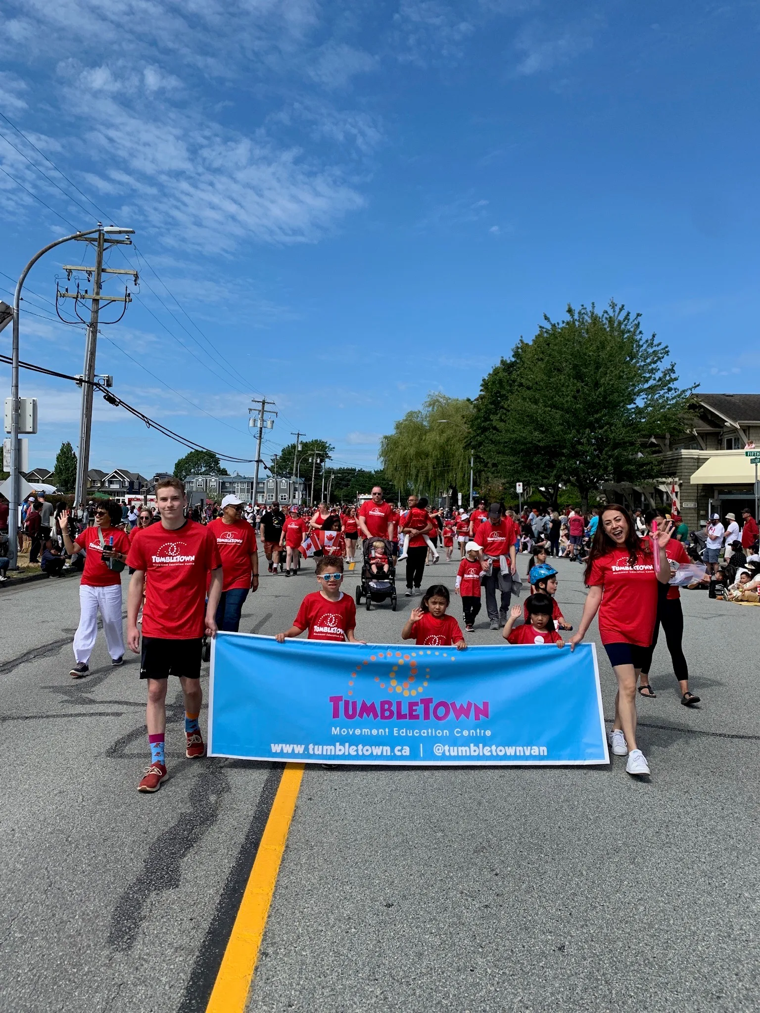 TumbleTown kids and coaches marching with the banner at the Steveston Salmon Festival parade