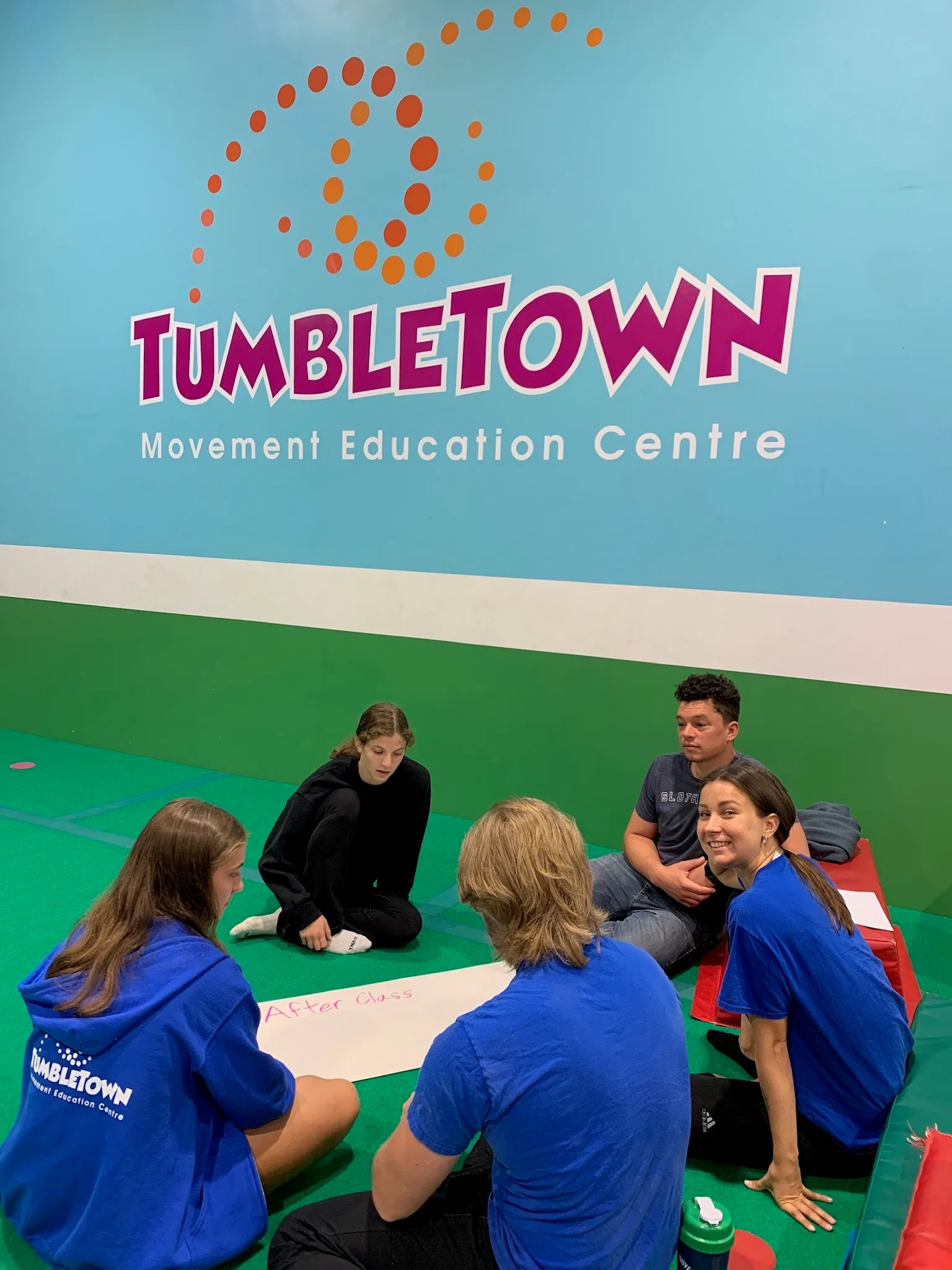 TumbleTown coaches meeting together on the gym floor