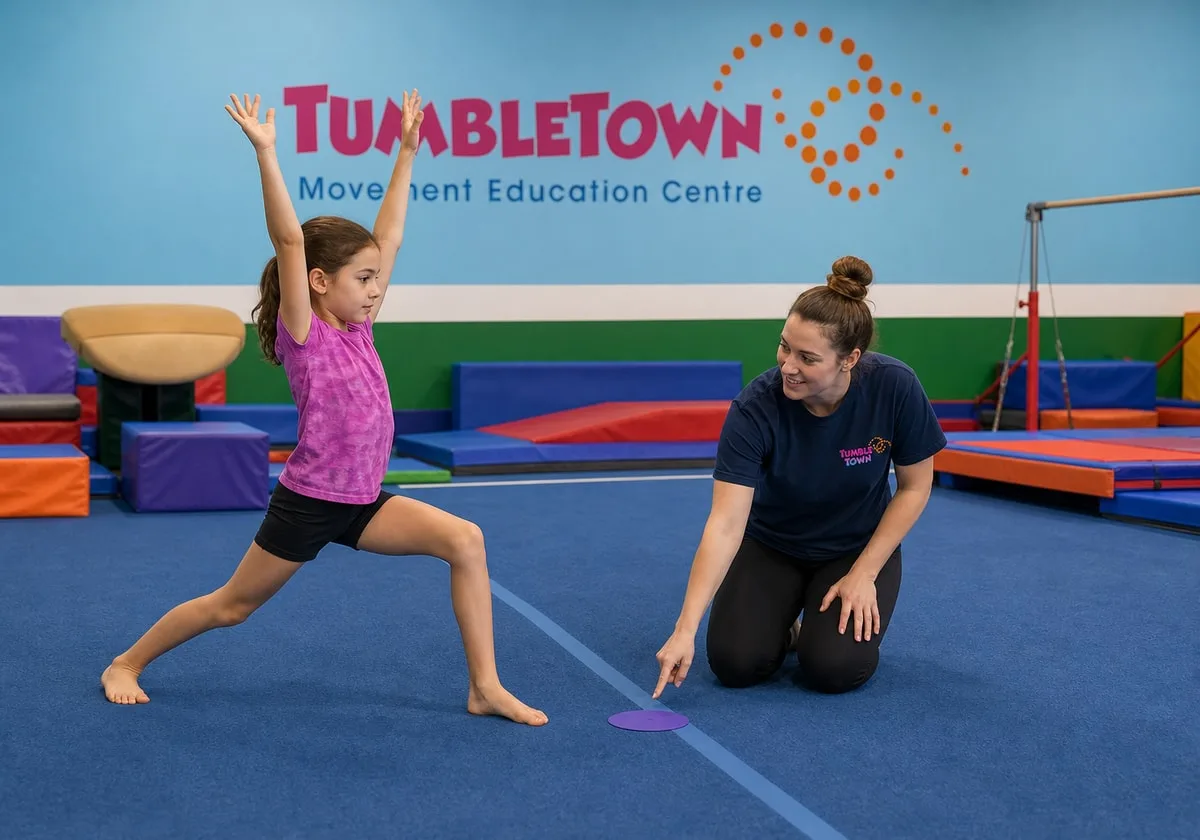 Nine-year-old practicing a cartwheel entry lunge with a female TumbleTown instructor