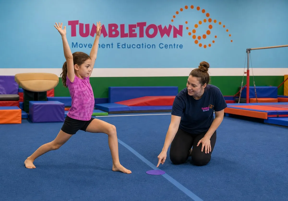 Nine-year-old practicing a cartwheel entry lunge with a female TumbleTown instructor